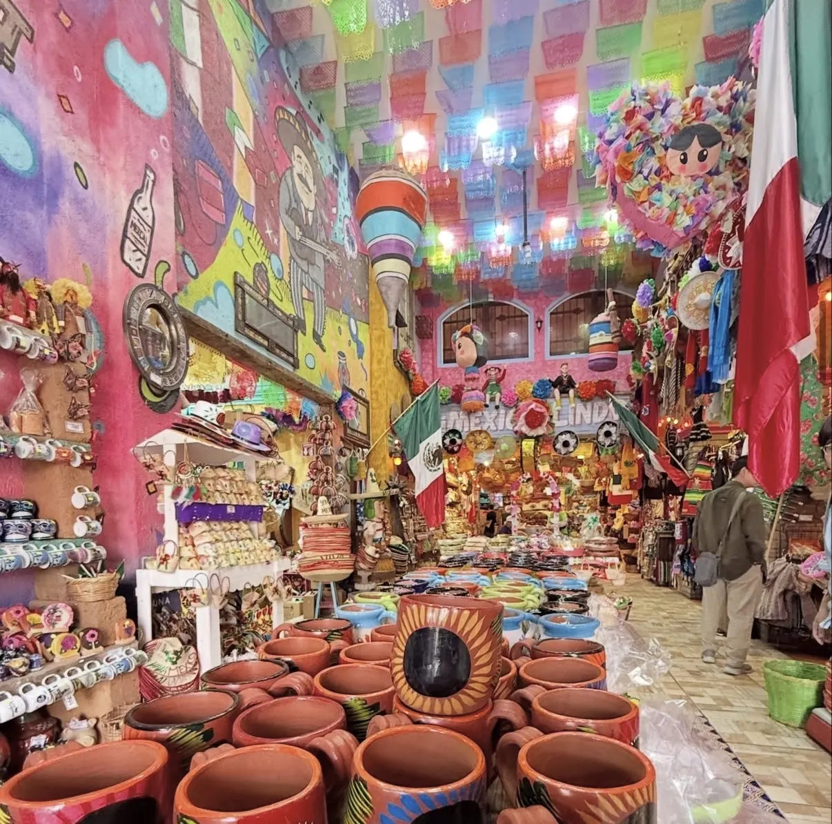 Pasillo de jarros de barro en La Dulcería Mexicana, con el letrero México Lindo al fondo